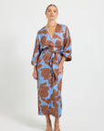Woman wearing a blue and brown floral print wrap midi dress.