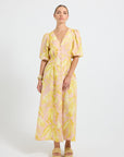Woman wearing a yellow and pink palm print Midi Shirt Dress