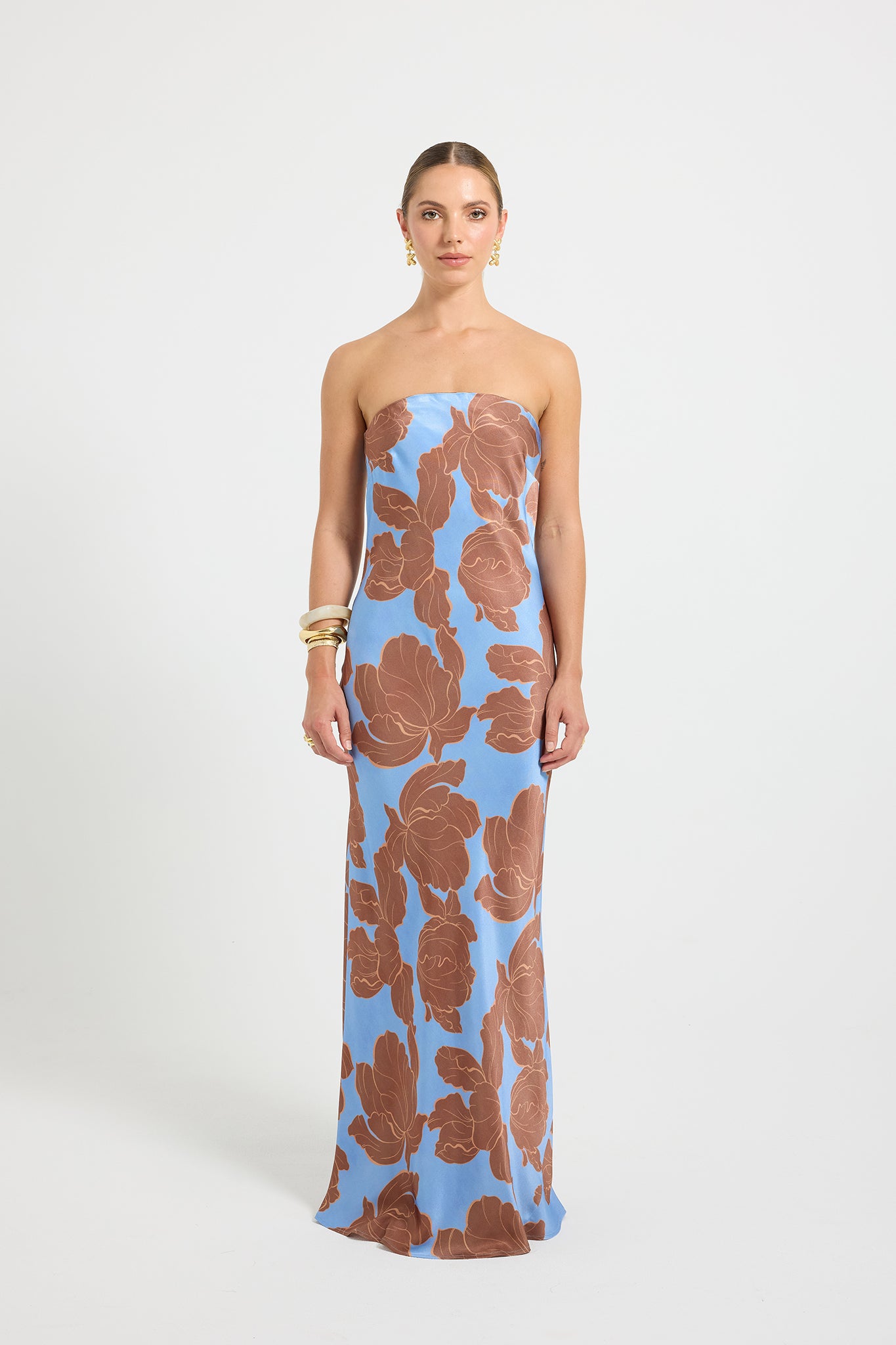 Woman wearing a strapless dress with a blue and brown floral print.