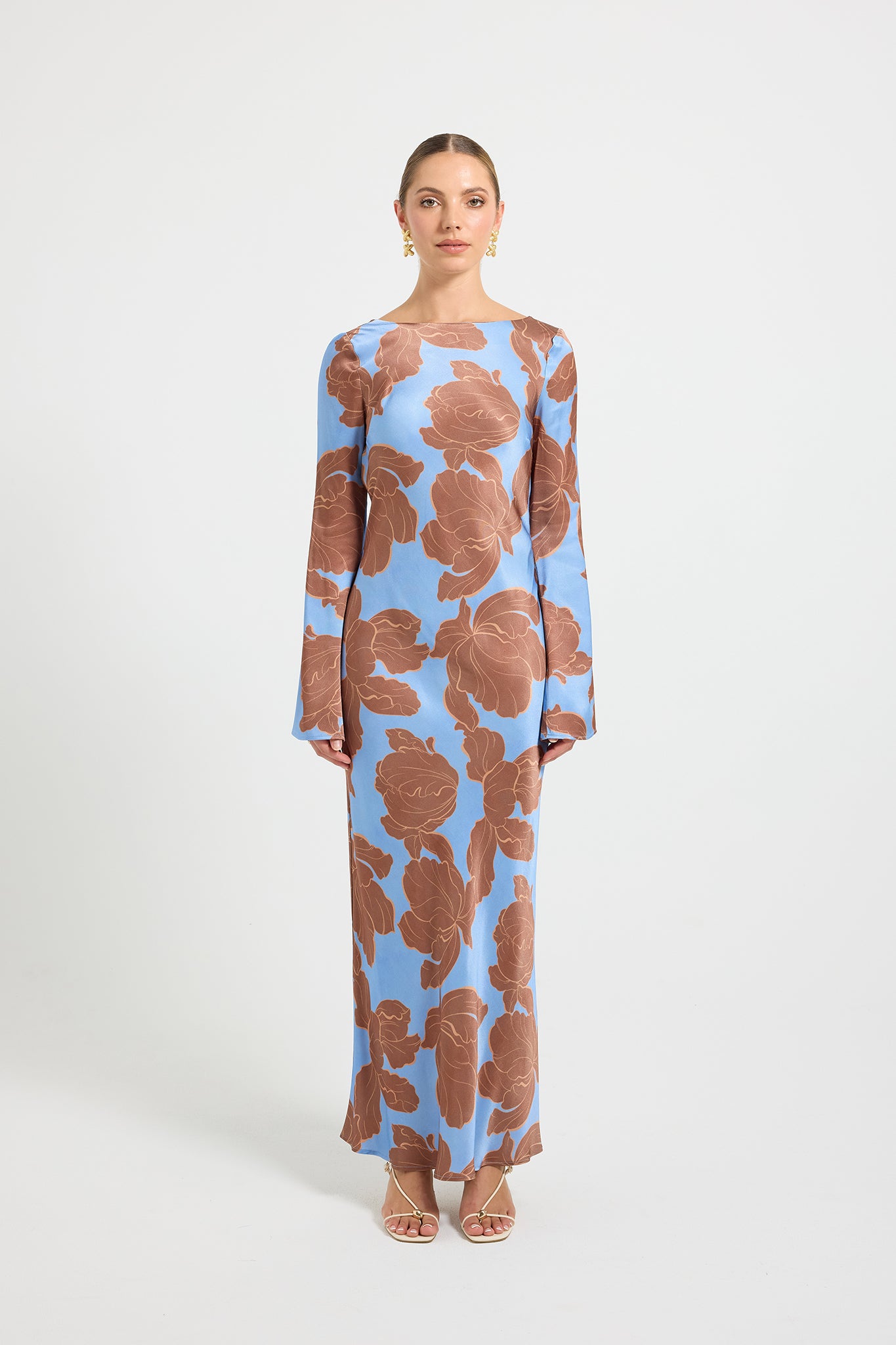 Woman wearing a long-sleeve blue and brown floral print dress.