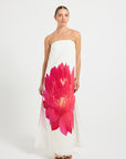 Woman wearing a strapless dress with a large pink flower design.