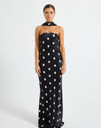 Model wearing a black and white polka dot strapless maxi dress