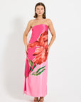 Model wearing a pink strapless maxi dress with floral design.