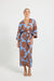 Woman wearing a blue and brown floral print wrap midi dress. 