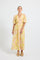 Woman wearing a yellow and pink palm print Midi Shirt Dress
