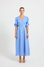 Woman wearing a light blue V-neckline button-through midi dress with elbow-length puffed sleeves.