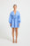 Woman wearing a light blue linen V-neckline long-sleeve mini dress.