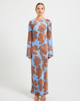 Woman wearing a long-sleeve blue and brown floral print dress.