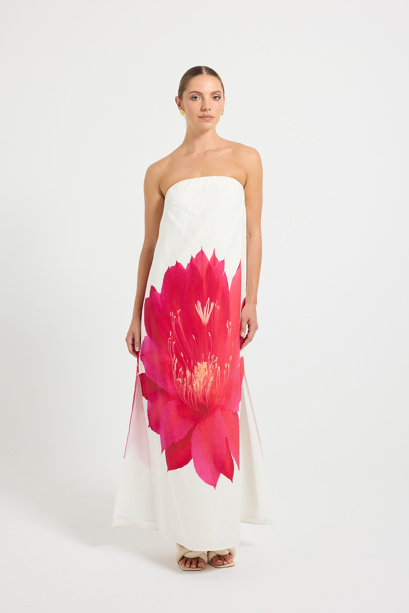 Woman wearing a strapless dress with a large pink flower design.