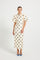 Woman wearing a Cream & Black polka dot Midi dress with short puff sleeves.
