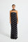 Model wearing a black and white polka dot strapless maxi dress