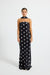 Model wearing a black and white polka dot strapless maxi dress
