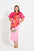 Woman wearing a pink midi dress with puff sleeves with red floral design. 